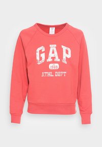 Felpa color corallo con maniche raglan, logo bianco "GAP" e scritta "ATHL. DEPT". Presenta scollo rotondo e polsini e orlo a costine.