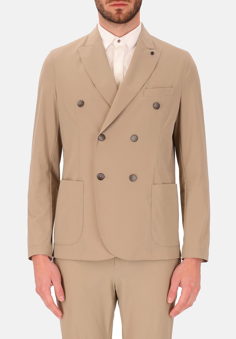 Beige dubbelzijdig jasje gemaakt van gladde stof met twee voorkanten zakken en donkere knoopaccenten. Inclusief een notch lapel en een getailleerde pasvorm.