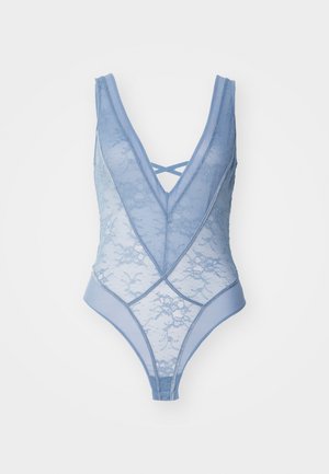 Helehall sinine pitsist bodi sügava V-kaelusega, millel on risti läbivad õlapaelad ja kehakuju rõhutav õhuke disain. Siledad servad kontrastsete detailidega.