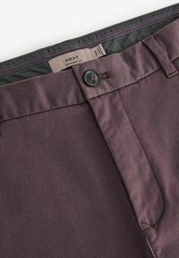 Lige pasform bukser i mørk burgundy stof med en glat tekstur. Har en knaplukning og mønstret taljebånd.