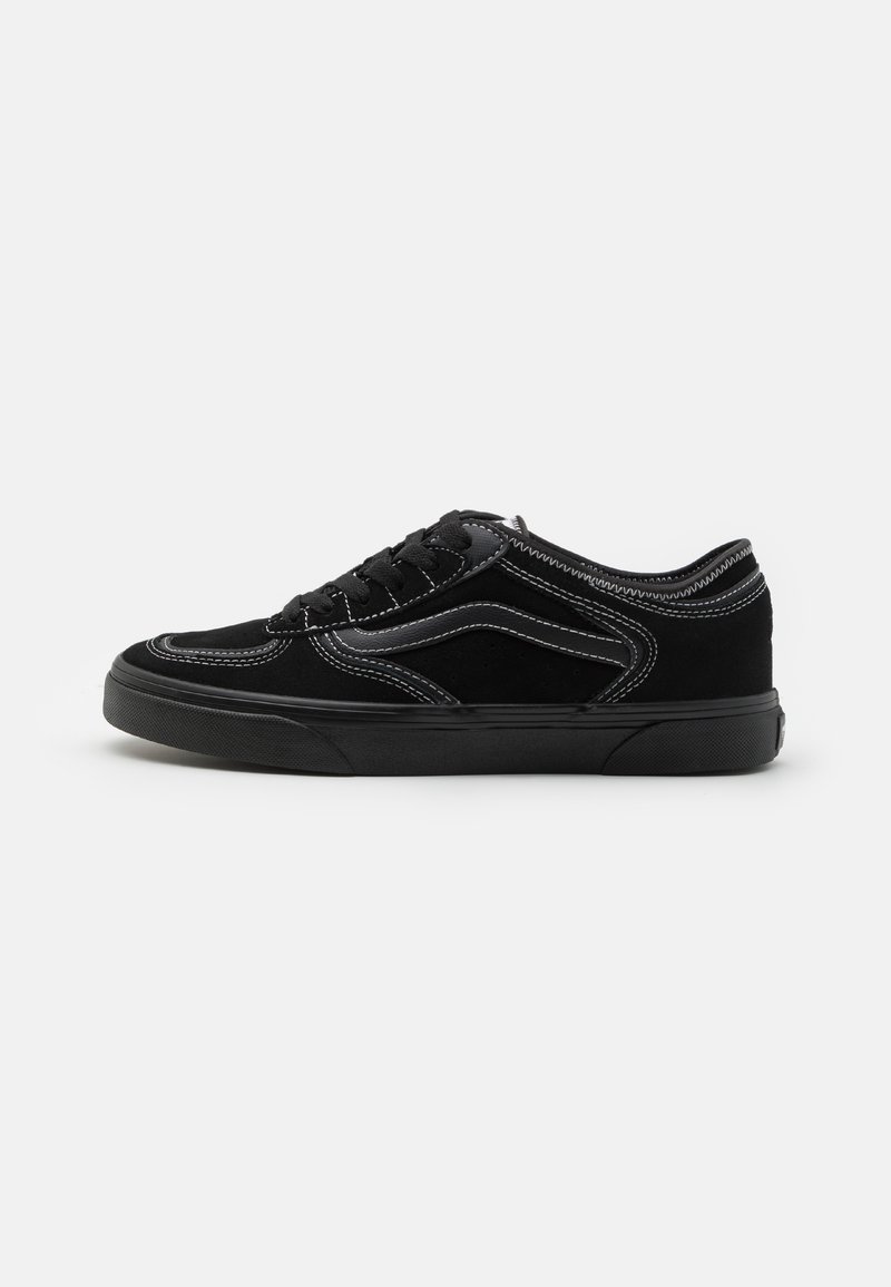 Sorte semskede sneakers med rund tå, med kontrasterende hvite sømmer og en teksturert gummisåle, snøring.