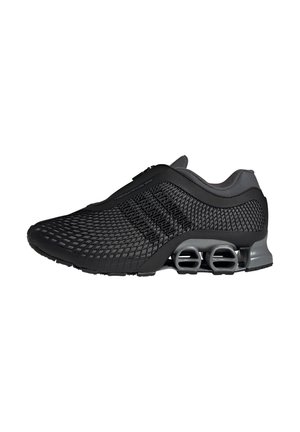 Chaussure de sport noire avec tige en mesh, fermeture éclair intégrée, et double amortisseur à ressort au talon pour un confort supplémentaire.
