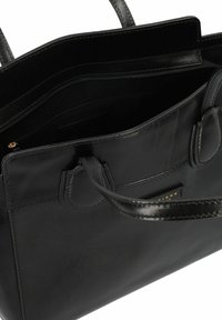Borsa tote in pelle nera con due manici, tasca interna con zip, texture liscia e dettagli di cucitura sottili. Accenti in hardware dorato visibile.