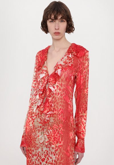 Long-sleeve dress in sheer red fabric with animal print and ruffles along the neckline, featuring a deep V-cut and delicate detailing.