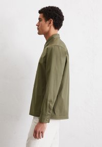 Olijfgroene button-up shirt met kraag, lange mouwen en een relaxte pasvorm. Gemaakt van een zachte stof met zijdetails.