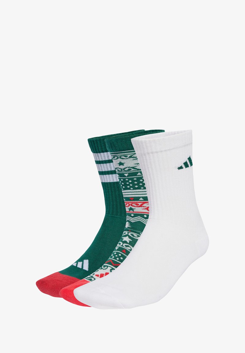 Trois paires de chaussettes : une verte avec des rayures blanches, une blanche avec des accents verts, et une à motifs avec des designs festifs en rouge, vert et blanc.