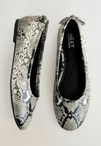 Ballerinasko med sort-hvidt slangeprint, lavet af struktureret syntetisk materiale, med en sløjfedetalje foran.