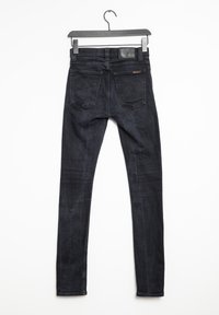 Tmavé džíny skinny s hladkým povrchem, s designem pěti kapes a koženou nášivkou na pásu. Zadní pohled.