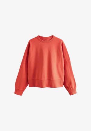 Koraļkrāsas sporta džemperis ar apaļu kakla izgriezumu, garām piedurknēm, ribveida aprocēm un apakšmalu, attēlots uz balta fona.