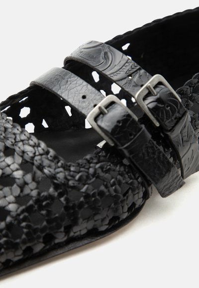 Μαύρο πλεκτό δερμάτινο σανδάλι με δύο ανάγλυφες ρυθμιζόμενες αγκράφες και σχεδιασμό ανοιχτής μύτης.