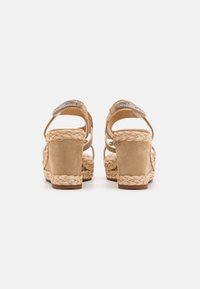 Sandali platform beige con tacchi avvolti in juta intrecciata, dotati di una tomaia in suede e cinturini decorati con strass.
