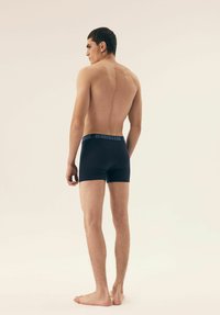Navy cotton boxers with a HENDERSON logo waistband, featuring a fitted design and smooth texture, viewed from the back.