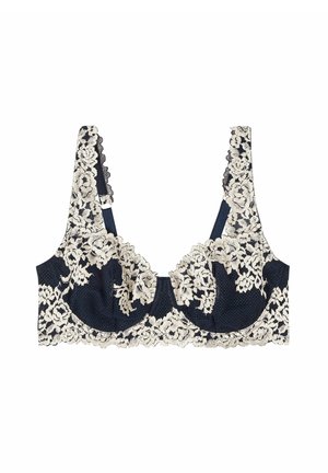Sostén de encaje con base azul marino, superposición de encaje floral crema, bordes en forma de ola y tirantes ajustables. Diseñado con aros para soporte.