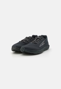Baskets de sport noires en tissu en mesh respirant. Présentent un design structuré, des lacets et une semelle rembourrée pour le confort.