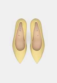 Κίτρινες μπαλαρίνες μυτερού σχήματος από λείο υλικό. Μινιμαλιστικός σχεδιασμός με ελαφρώς ανυψωμένη σόλα και επενδεδυμένο πάτο για άνεση.