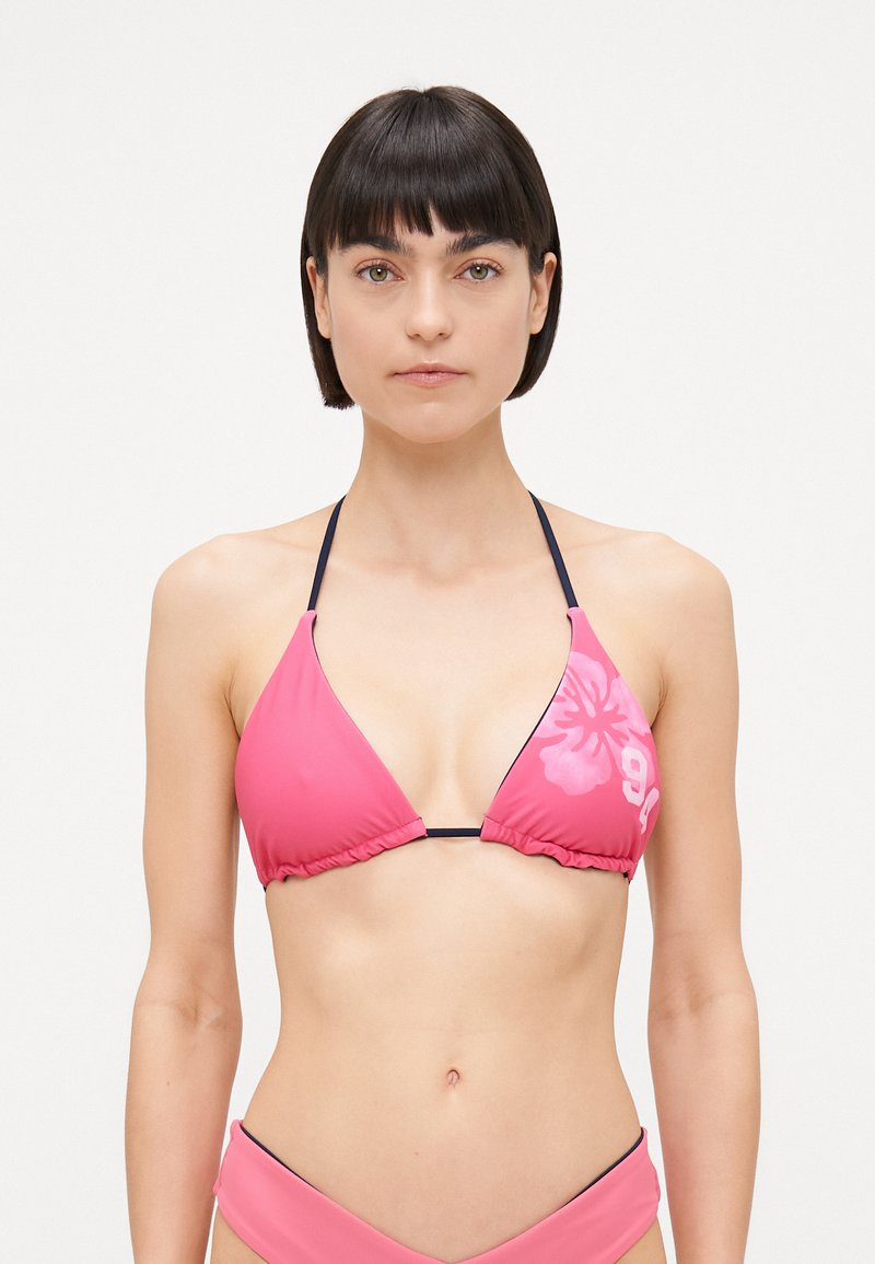 Ružičasti bikini top s trokutastim čašama, crnim trakama i cvjetnim uzorkom s jedne strane. Izrađen od glatkog, rastezljivog materijala.