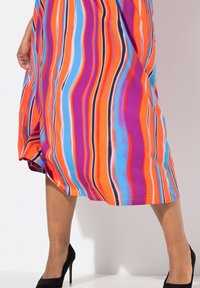 Abito colorato al ginocchio con strisce ondulate vibranti in arancione, blu, viola e nero; realizzato in tessuto liscio e leggero.