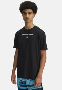 Svart bomulls t-shirt med korta ärmar, med vit text "JAG KAN GÖRA ALLT" på framsidan och en handlogga under.