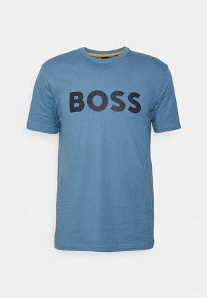 Modrá bavlnená tričko s okrúhlym výstrihom, s výrazným čiernym logom "BOSS" naprieč hrudníkom. Krátke rukávy a hladká textúra.