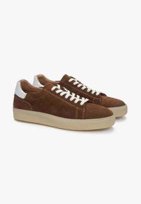 Brązowe zamszowe sneakersy z białymi akcentami na pięcie, gumową podeszwą i beżowymi sznurówkami. Klasyczny niski model z minimalnymi detalami w ściegach.