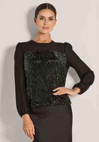 Schwarzes Langarmoberteil mit einem besetzten Vorderteil, glattem Stoff an den Ärmeln und einem runden Ausschnitt. Slim Fit mit einem dezenten Glanz.