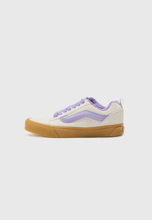 Lågt profil sneakers med en överdel av krämfärgad mocka och lavendelaccenter. Har en sula i gummirubber och en texturerad krage för extra komfort.