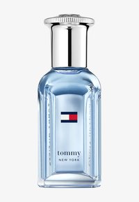 Botella de perfume de vidrio transparente con forma rectangular, tapa plateada y líquido azul claro. Presenta un logotipo rojo, blanco y azul en la parte frontal.