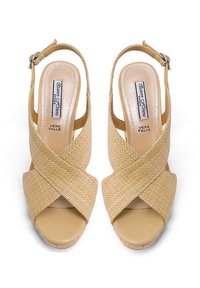 Sandalias de cuña beige con diseño de tiras trenzadas entrecruzadas, que cuentan con puntera descubierta, correa ajustable en el tobillo y forro interior suave.