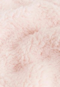 Jasnoróżowy, puszysty materiał o miękkiej, teksturowanej powierzchni, z wysokim włosiem i przytulnym wyglądem. Odpowiedni do koców lub odzieży.