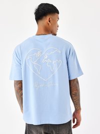 Camiseta de algodón azul claro con un diseño de mapa mundial en blanco, con el texto "Project Paris" debajo, cuello redondo y mangas cortas.