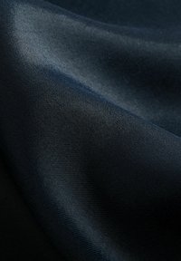 Dunkelblaues Gewebe: glatte Textur mit subtiler Glanz, leicht zerknittertes Aussehen, feines Webmuster, fließend fallend.
