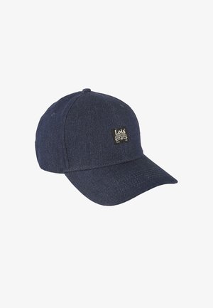 Gorra de denim azul oscuro con visera curva, que presenta un pequeño parche negro con el logo en la parte frontal. El material parece texturizado y resistente.