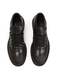 Zapatos altos de cuero negro con punta redondeada, parte delantera con cordones y ojales metálicos, y un cuello acolchado para soporte.