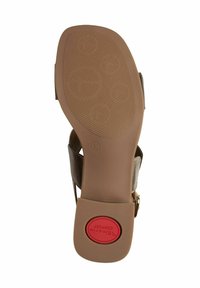 Brun sandal med en strukturerad gummisula. Har ett metallspänne och en vadderad sula. Storlek 37 märkt på undersidan.
