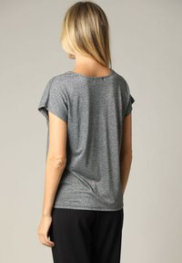 Grijze t-shirt met korte mouwen in een ontspannen pasvorm, licht afgeronde halslijn en textuurstof. De achterkant is glad met een klein centraal naaddetail.