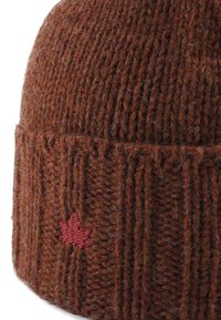 Bonnet en tricot marron avec une texture côtelée. Présente une feuille d'érable brodée bordeaux sur le revers. Matériau en laine chaud et doux.