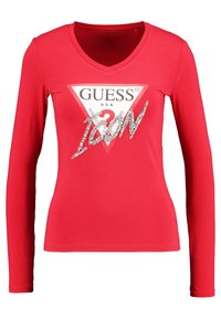 Camiseta roja de manga larga con escote en V, con un diseño de logo en forma de triángulo y brillantes decorativos que deletrean "ICON" en la parte frontal.
