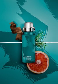 Cyan rostfritt stål vattenflaska med ett silverlock, med en texturerad design och texten "ICEBERG TWICE CYAN." Åtföljd av en grapefruktskiva och trädetaljer.