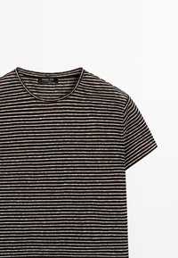 Zwart-wit horizontaal gestreept T-shirt met korte mouwen, een ronde halslijn en een Massimo Dutti-label aan de binnenkant van de kraag.