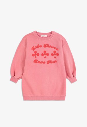 Rosa Sweatshirt aus weichem Stoff, mit rundem Halsausschnitt, ausladenden Ärmeln und rotem Text sowie vier Kleeblattmotiven, die auf der Vorderseite gedruckt sind.