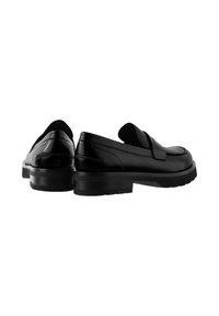 Zwarte leren loafers met een gladde afwerking, voorzien van een lage hak en een rubberen zool. Vergezeld van een platte band over de wreef.