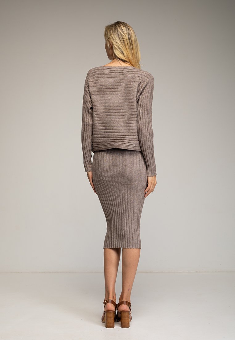 Geschenkset aus Strickpullover und Bleistiftrock in Taupe mit gerippter Textur, langen Ärmeln und figurbetontem Schnitt. Holzsandalen mit Absatz runden das Outfit ab.