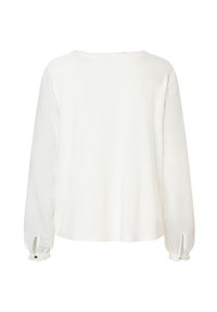 Witte blouse met lange mouwen en ruches bij de halslijn en manchetten, met knoopslits op de mouwen, van achteraf weergegeven op een effen achtergrond.