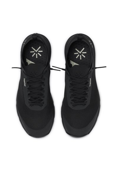 Black athletic shoes with a mesh upper, round toe, and flat sole. Features laces, branding text, and a reflective accent.