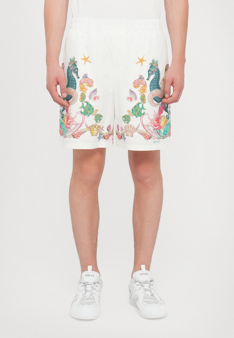 White swim shorts featuring colorful sea-themed embroidery, including seahorses, fish, and shells. Elastic waistband for comfortable fit.