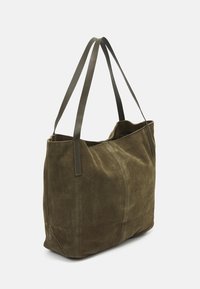 Bolso tote de ante verde oliva con dos asas de cuero, parte superior abierta y textura suave. Presenta detalles de costura vertical a los lados.