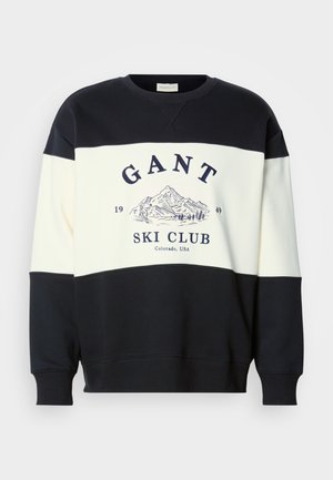 Black and white colorblock sweatshirt with "GANT Ski Club 1949 Colorado, USA" text and mountain and skier graphic on the chest.