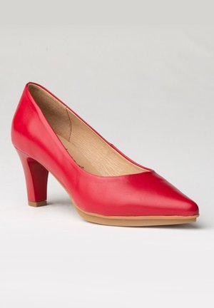 Zapato de tacón alto de cuero rojo con punta afilada, tacón cuadrado de 3 pulgadas y un acabado suave. El interior presenta una textura de madera natural.