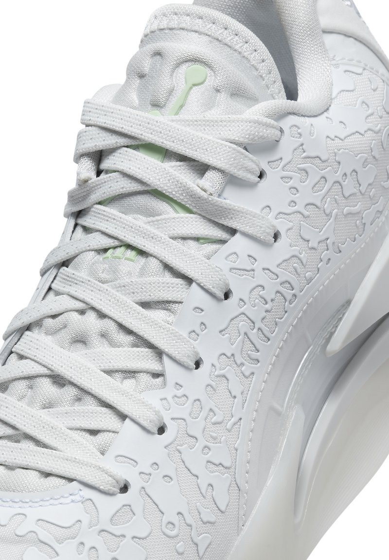 Baskets blanches avec tige texturée, motifs en relief complexes et lacets plats. Présentent une semelle lisse et brillante.
