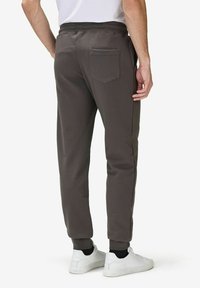 Harmaat slim fit -housut, joissa on teksturoitu kangas, joustava vyötärö, sivutaskut ja yksi takatasku. Valkoiset lenkkarit täydentävät asukokonaisuuden.
